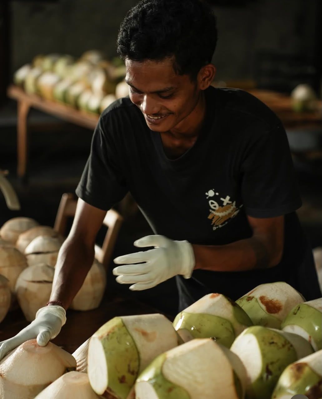 A Cocohub team member preparing peeled young coconuts